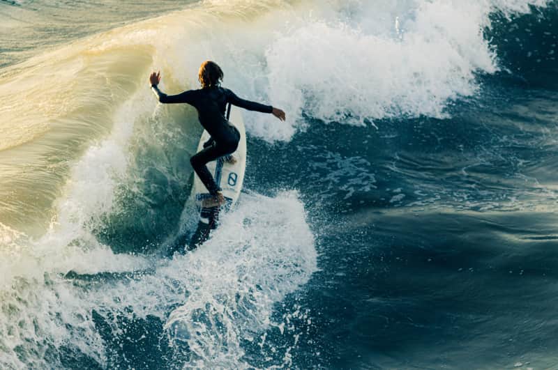 Woman standing on a surfboard | Point Break