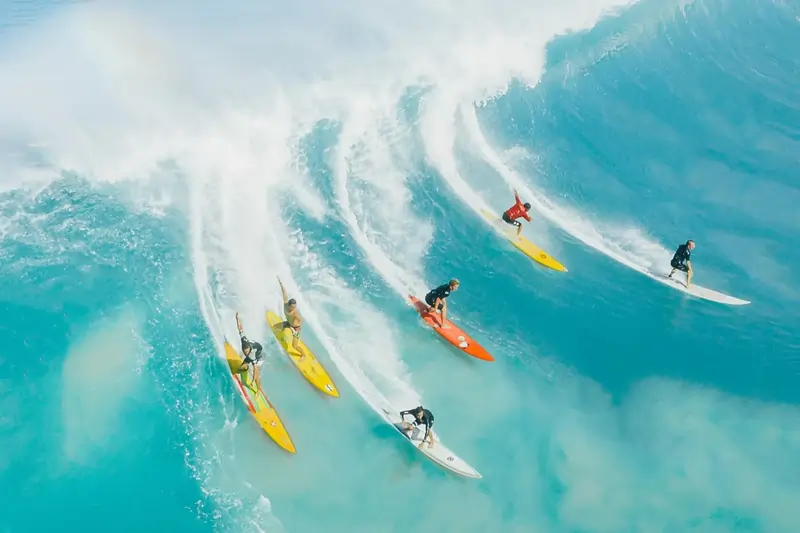 Surfers riding a high wave | Point Break School