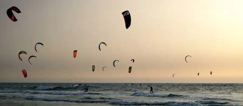 Beach populated by many kitesurfers | Point Break