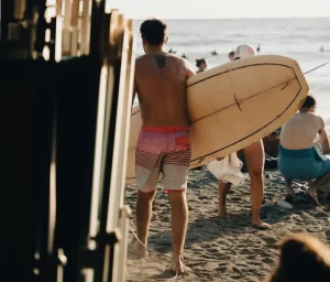 Surfista con la tavola in mano che si avvicina all'acqua | Point Break